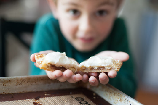 kid holding apple turnovers with cream cheese